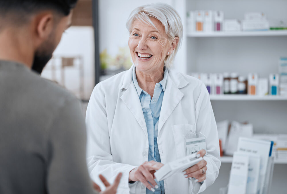 Happy pharmacist advising customer